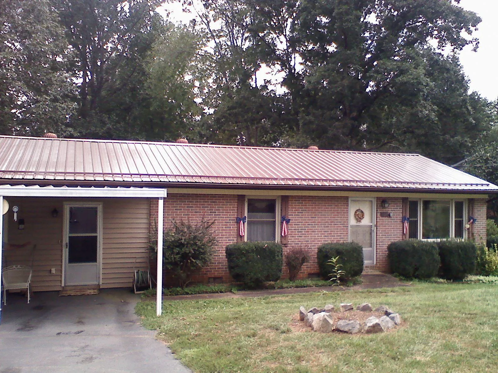 Bronze metal roof and carport on a brick ranch home — Roof Repair work by our crew in Superior